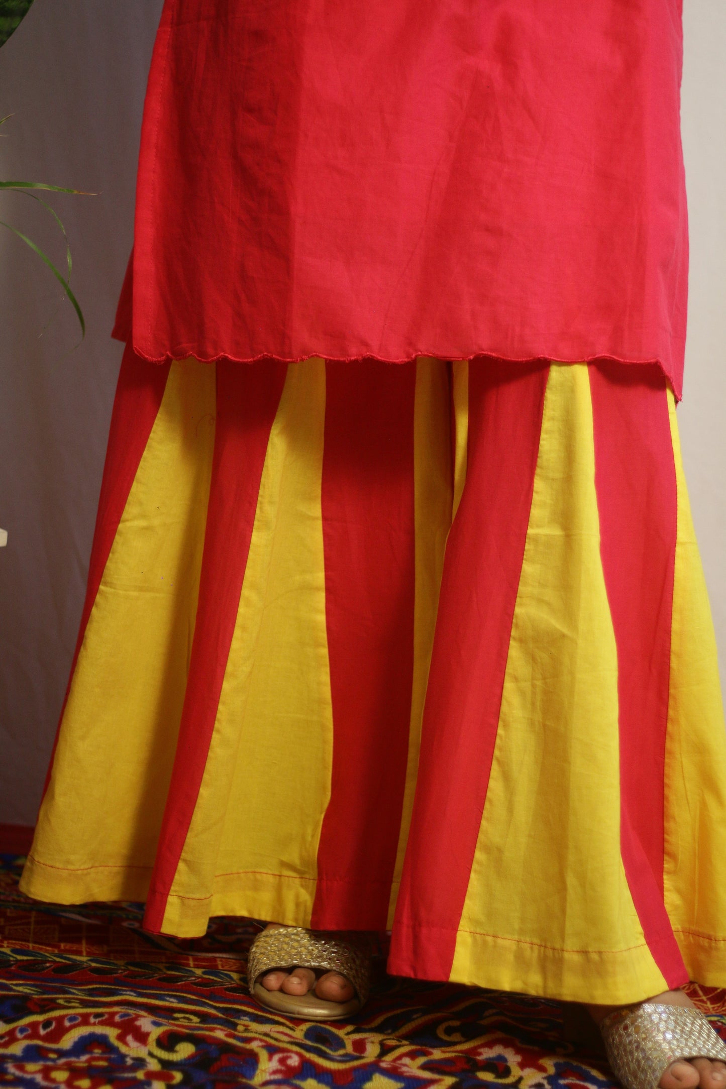 Red and yellow traditional outfit on a patterned rug