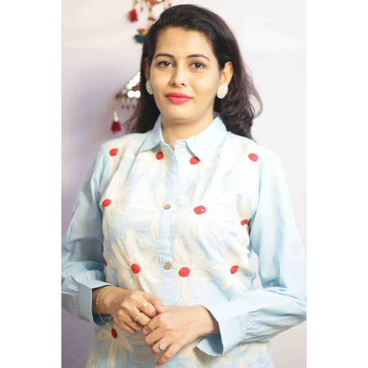 Woman wearing a light blue traditional outfit with red polka dots with Cord work Embroidery