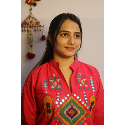 Woman wearing a red embroidered traditional outfit with a plain background