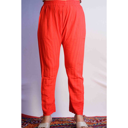 Red pants worn by a person on a plain background