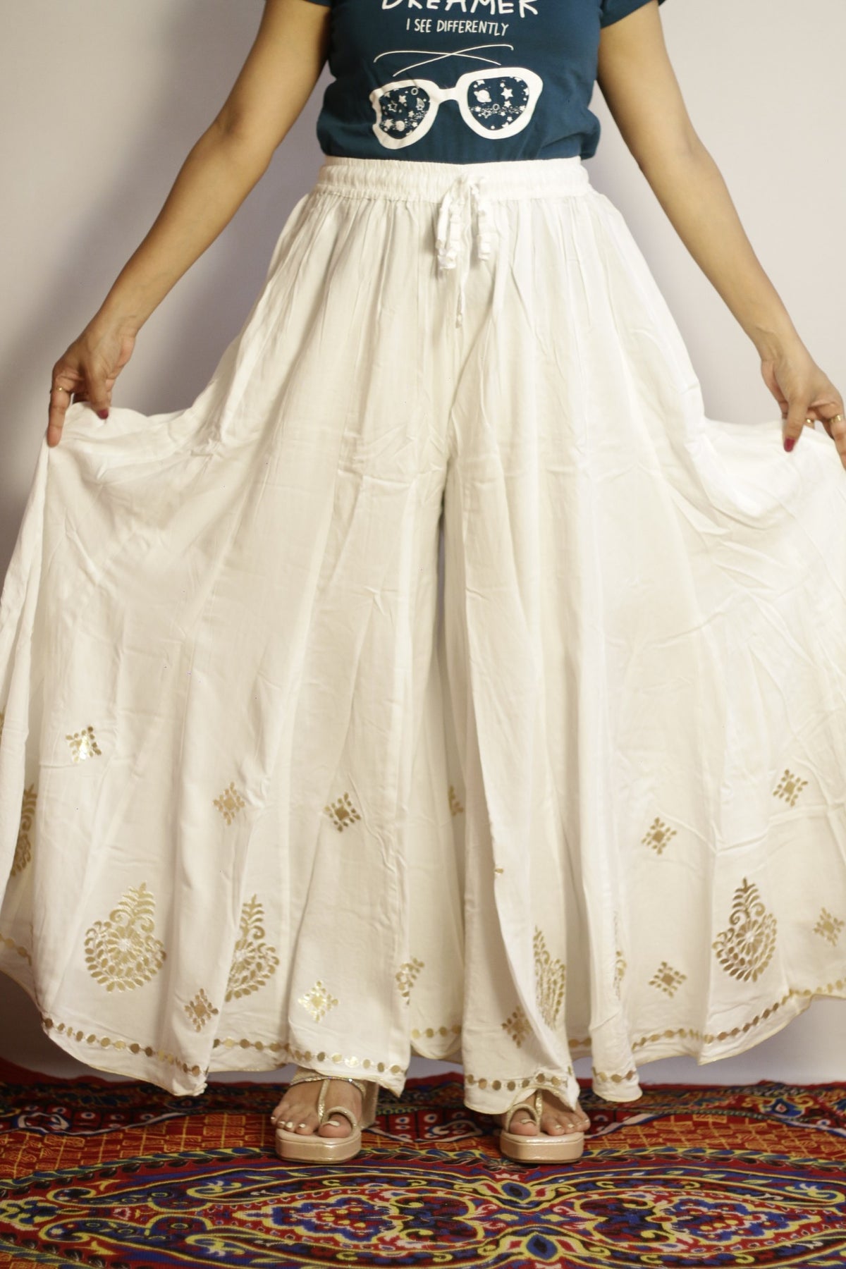 White gotta patti palazzo in heavy rayon, front view with gold work and flared drape