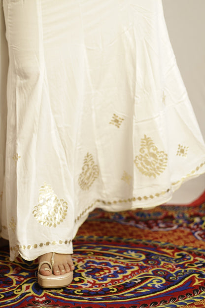Close up of gold gotta patti work and disc trim on the white palazzo hem