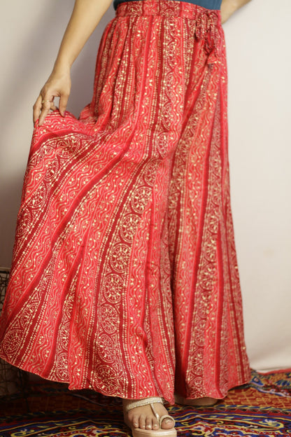 Pink printed palazzo side view showing the vertical gold panels and flare