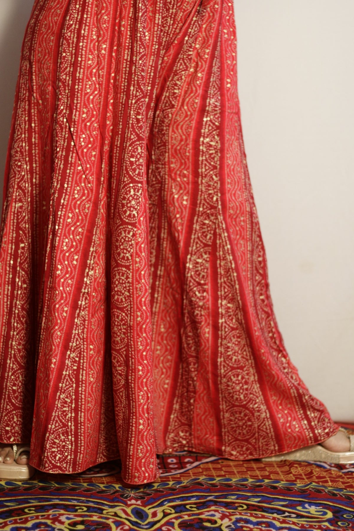 Close up of the gold bandhani style print and sequin work on the pink palazzo