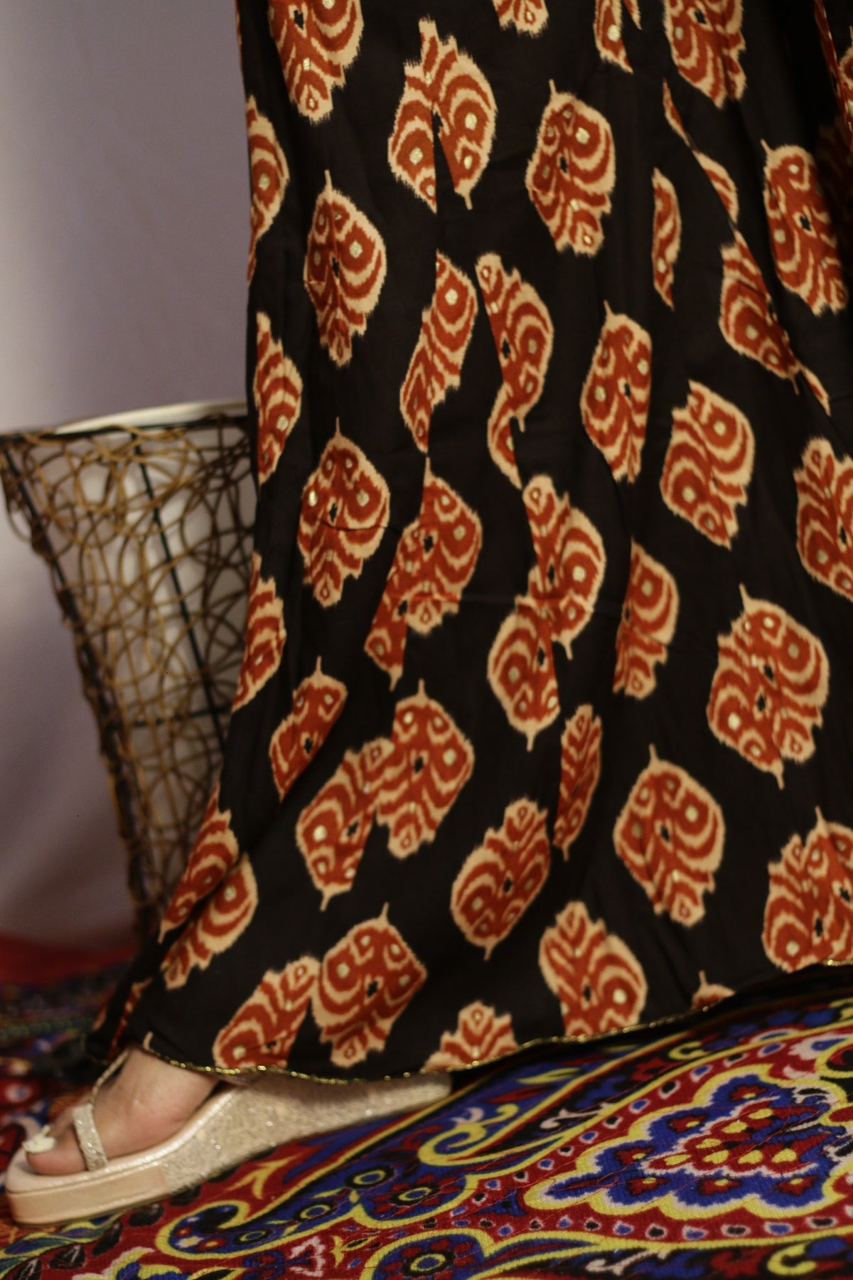 Close up of the rust ikat print and sequin work on the black kali palazzo