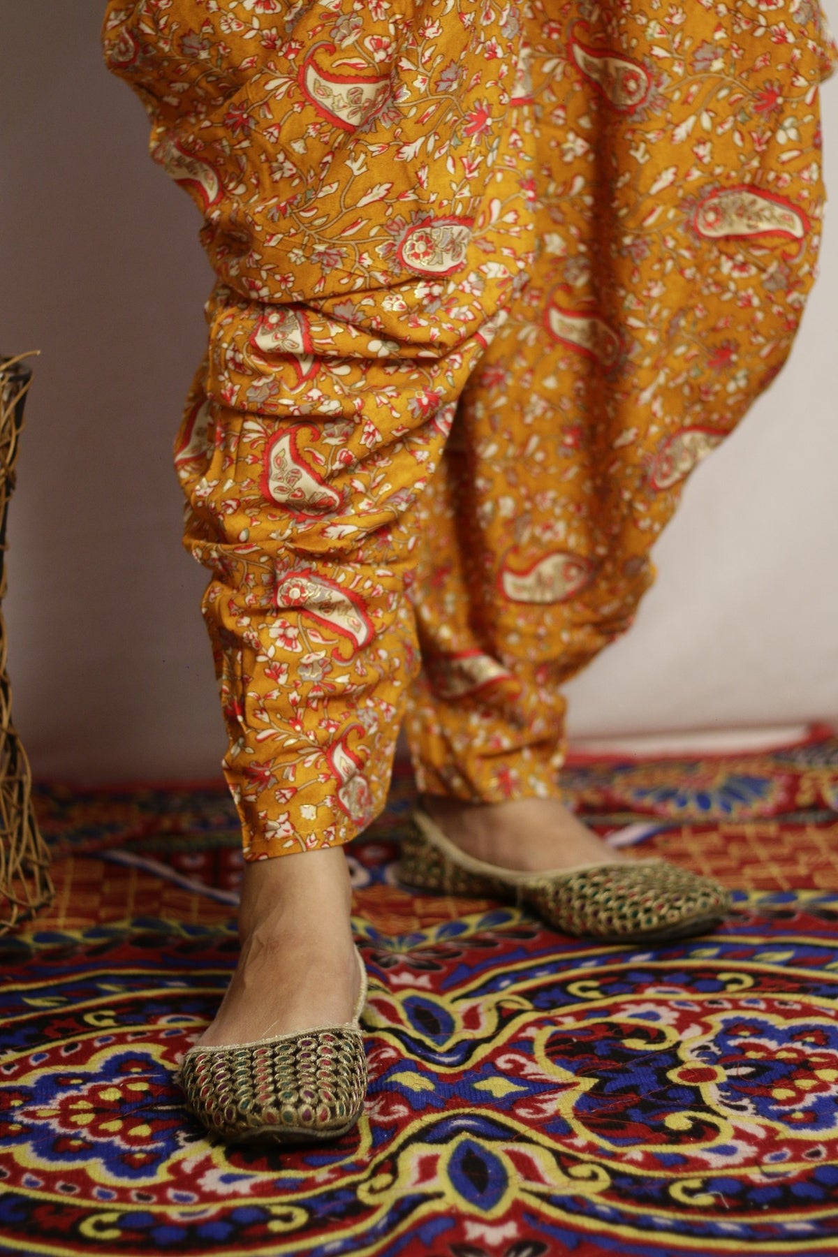 Close up of the tapered ankle and paisley print on the mustard dhoti pant