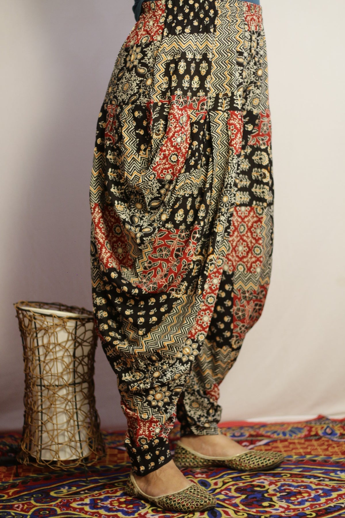 Black dhoti pant side view showing the draped folds at the hip