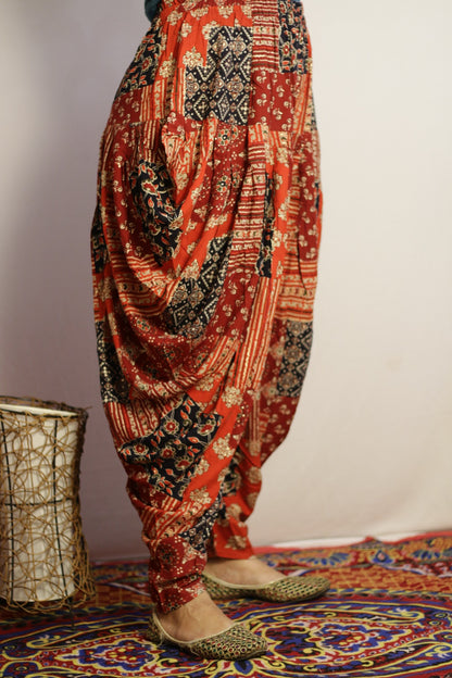 Red dhoti pant side view showing the deep drape and navy print blocks