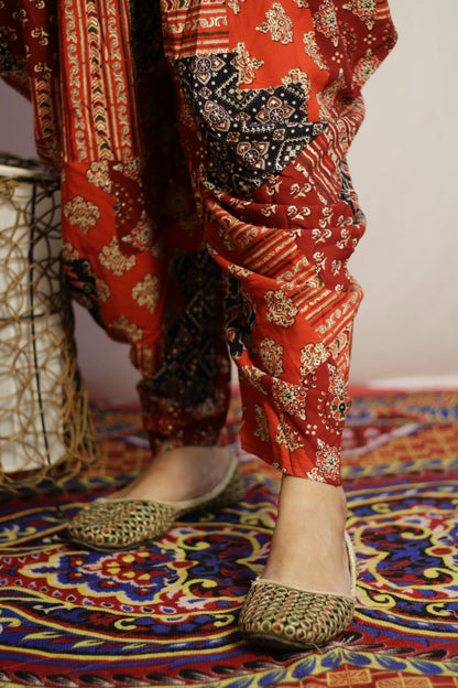 Close up of the tapered ankle and cream and gold print on the red dhoti pant