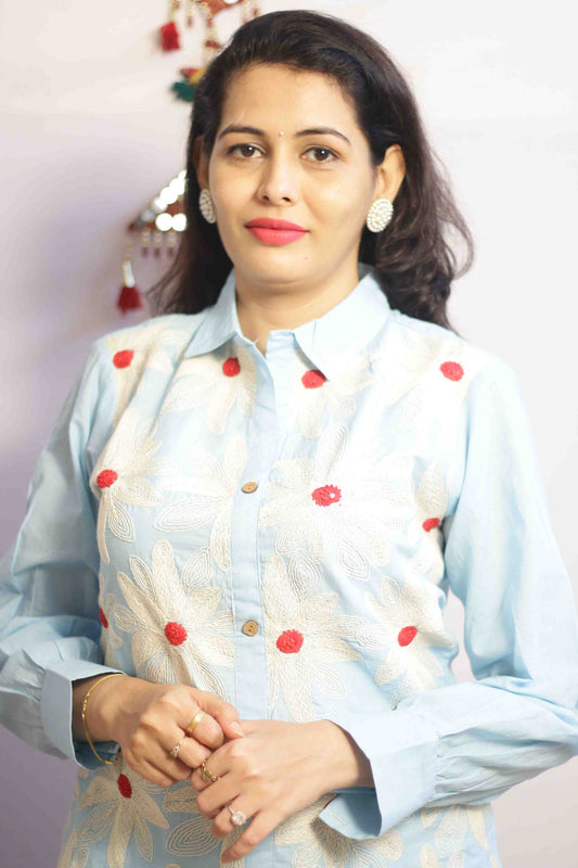 Woman wearing a light blue traditional outfit with red polka dots with Cord work Embroidery